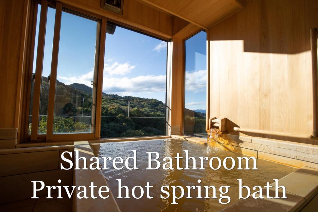 Cette grande chambre dispose d'une grande fenêtre et d'un bain de source chaude. dans l'établissement Chigira Jinsentei, à Shibukawa