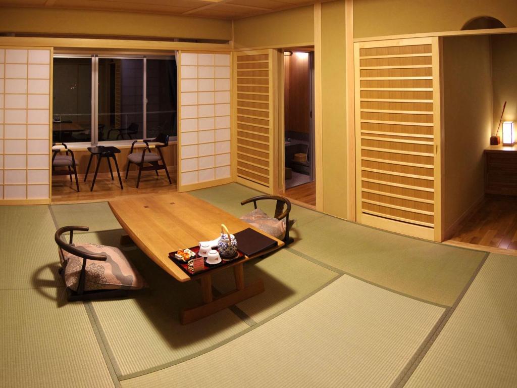 un salon avec une table et des chaises en bois dans l'établissement Gero Onsen Yukyunohana, à Gero
