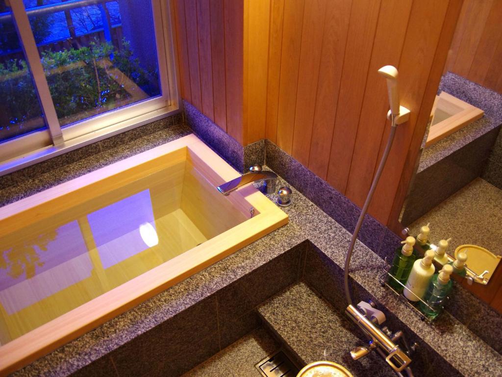 La salle de bains est pourvue d'une baignoire et d'un lavabo. dans l'établissement Gero Onsen Yukyunohana, à Gero
