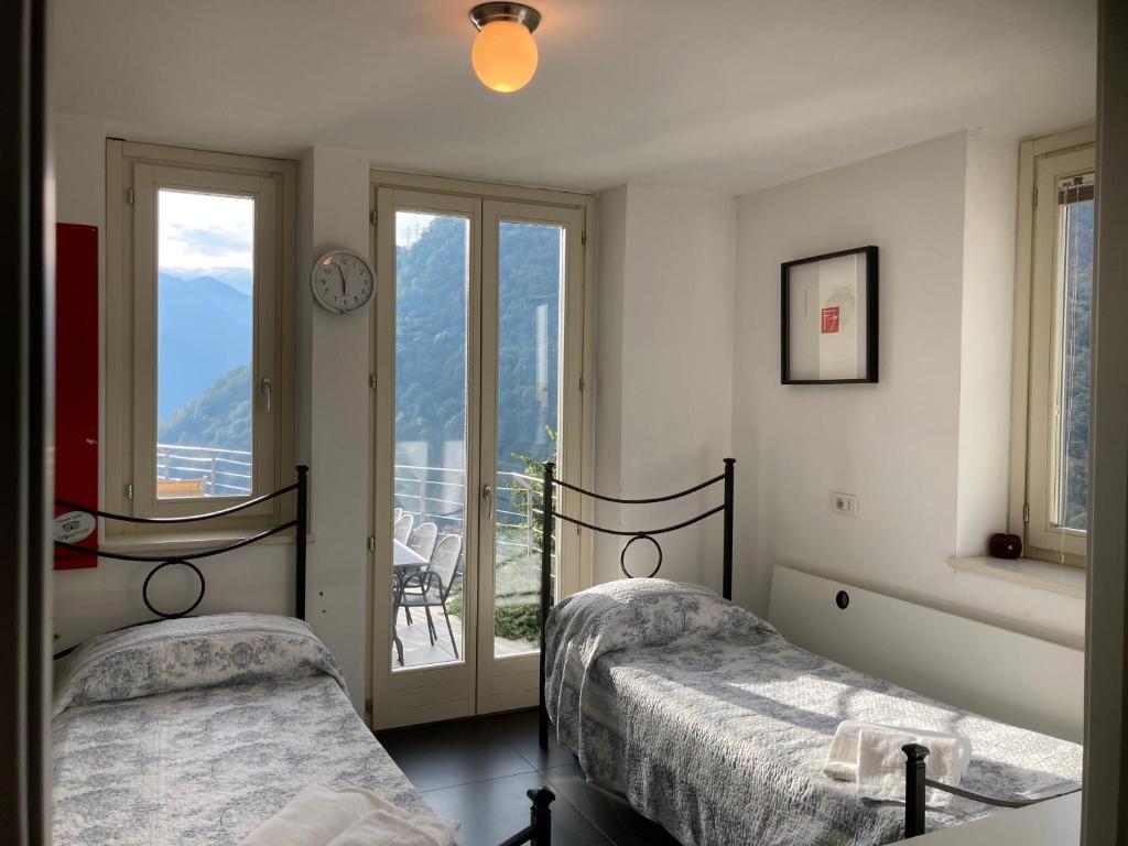 - une chambre avec 2 lits et une fenêtre avec vue dans l'établissement Ville Belvedere - by MyHomeInComo, à Muronico