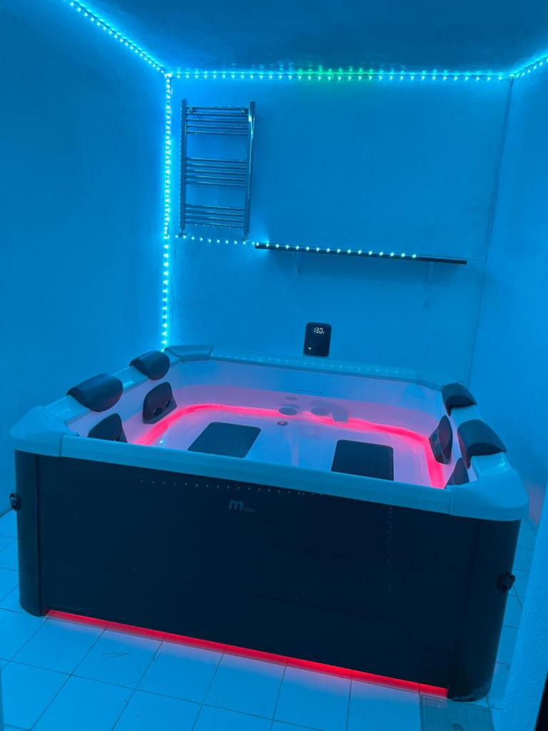- un bain à remous dans une chambre avec des lumières bleues dans l'établissement Villa Roma Open Space - Location per eventi 2 piscine riscaldate -, à Rome