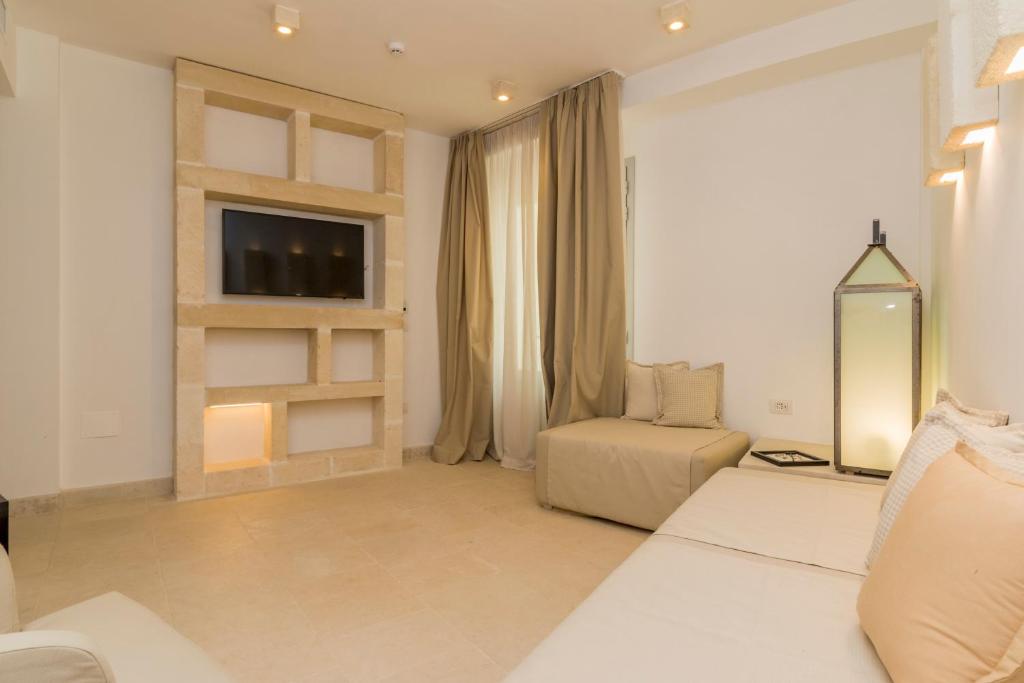 - un salon blanc avec une télévision et un canapé dans l'établissement HOTEL BARONE DI MARE, à Torre dell'Orso 28 autres photos