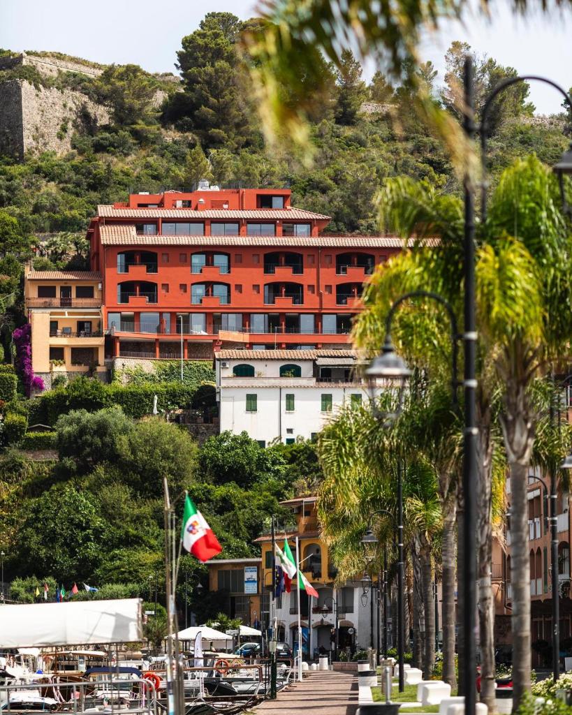 un grand bâtiment au sommet d'une colline plantée de palmiers dans l'établissement La Roqqa, à Porto Ercole