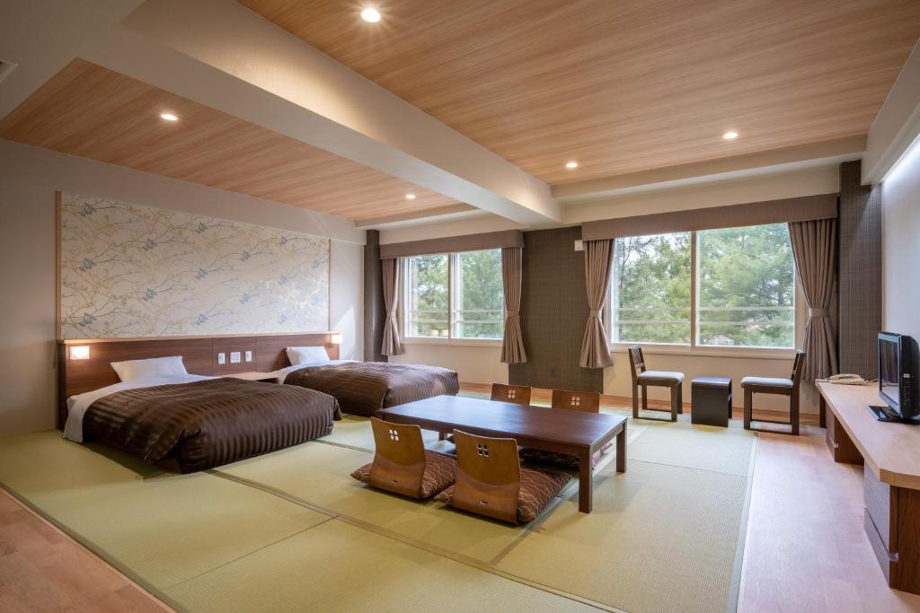 une chambre d'hôtel avec deux lits et une table dans l'établissement Hotel Daiheigen, à Otofuke
