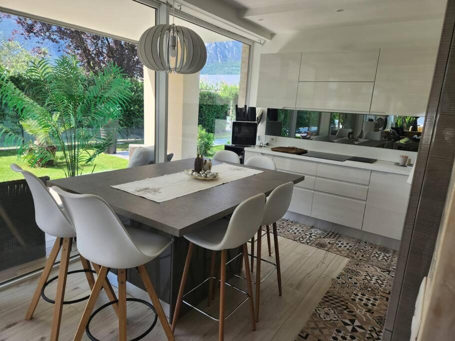 une cuisine avec une table et des chaises ainsi qu'une grande fenêtre dans l'établissement villa relax, à Riva del Garda