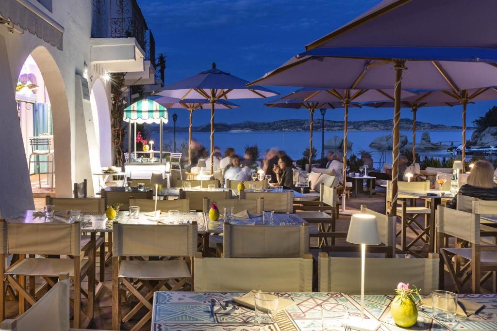 un restaurant avec des tables, des chaises et des parasols dans l'établissement Boutique Hotel Solaz, à Porto Rafael
