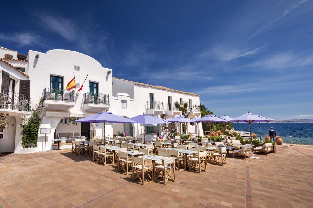 un groupe de tables et de chaises avec parasols devant un bâtiment dans l'établissement Boutique Hotel Solaz, à Porto Rafael