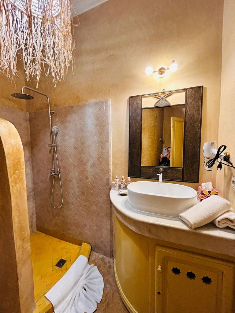 une salle de bain avec un lavabo et un miroir dans l'établissement Riad Bamaga, à Marrakech