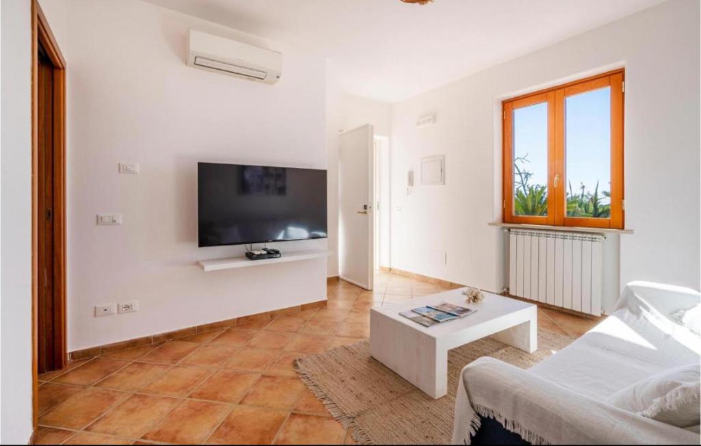Il comprend un salon blanc doté d'une télévision murale à écran plat. dans l'établissement Villa INARIME, à Ischia