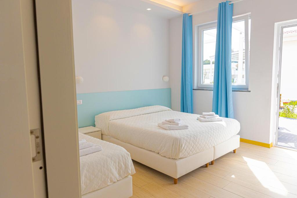 une chambre avec deux lits et un miroir dans l'établissement Resort Acqua di Venere, à Paestum 51 autres photos