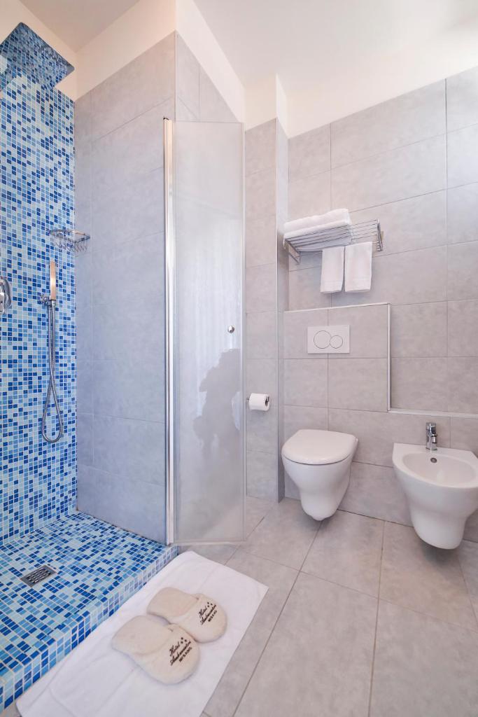 une salle de bain avec une douche, des toilettes et un lavabo dans l'établissement Ambasciatori Hotel - Beach Front -Breakfast XXL & Brunch until 12 30pm, à Misano Adriatico