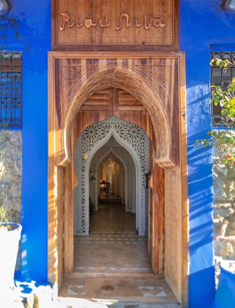 une entrée dans un bâtiment bleu avec une arche dans l'établissement Riad Nila, à Chefchaouen