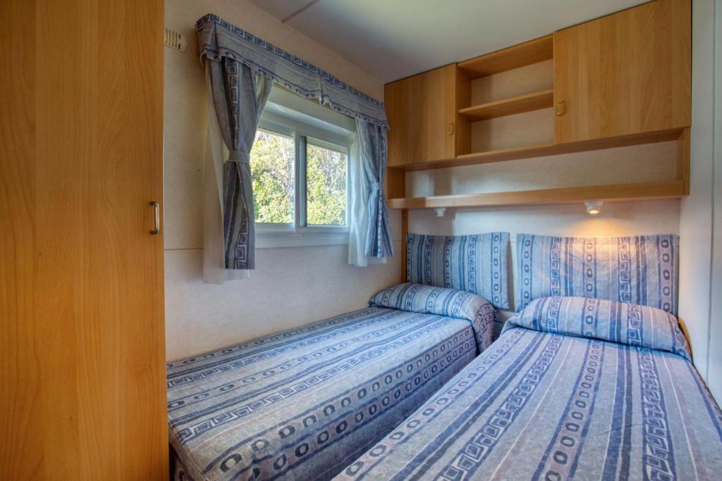 deux lits dans une petite pièce avec une fenêtre dans l'établissement Grotta del Saraceno, à Vasto