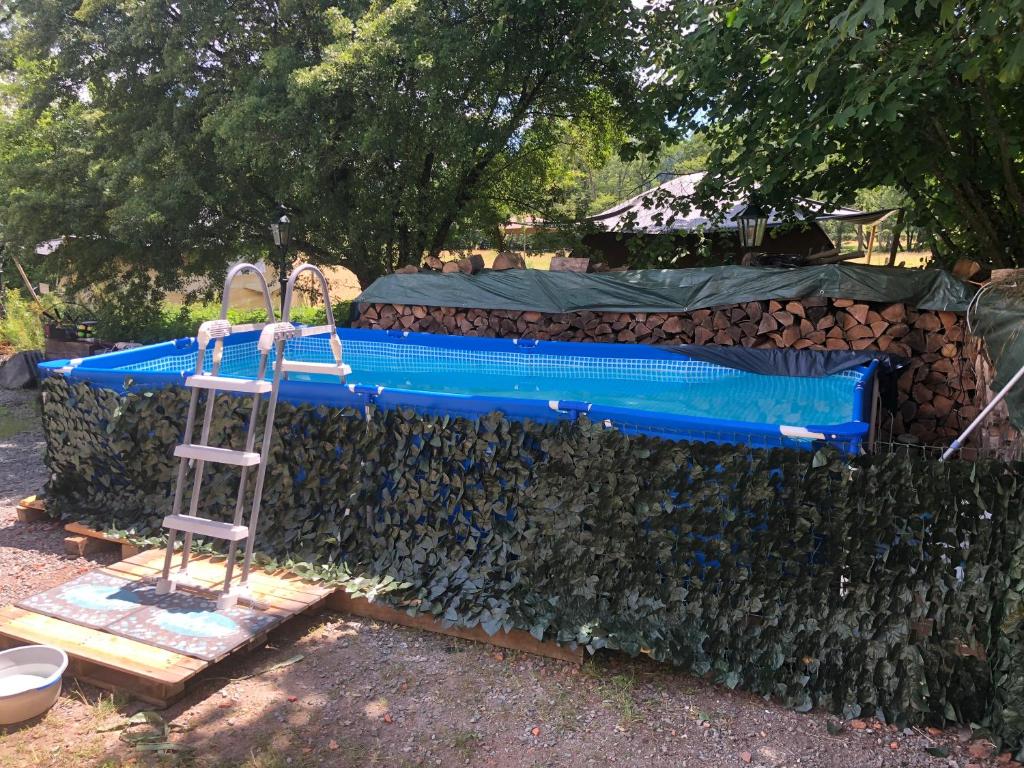 une échelle en face d'une clôture avec une piscine dans l'établissement Glamping Resort Bousset, à Chiddes