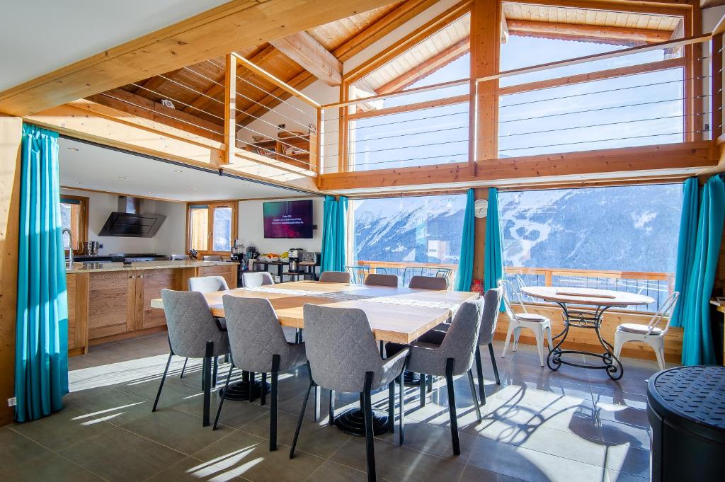 une cuisine et une salle à manger avec une table et des chaises dans l'établissement Chalet Evidence, à Montvalezan