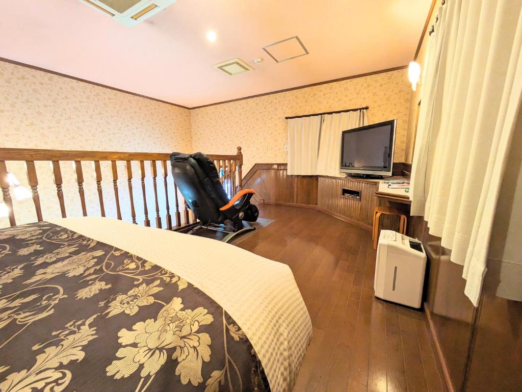 une chambre avec un lit et un bureau avec une télévision dans l'établissement SKY Ocean-terace Omura, à Omura 19 autres photos