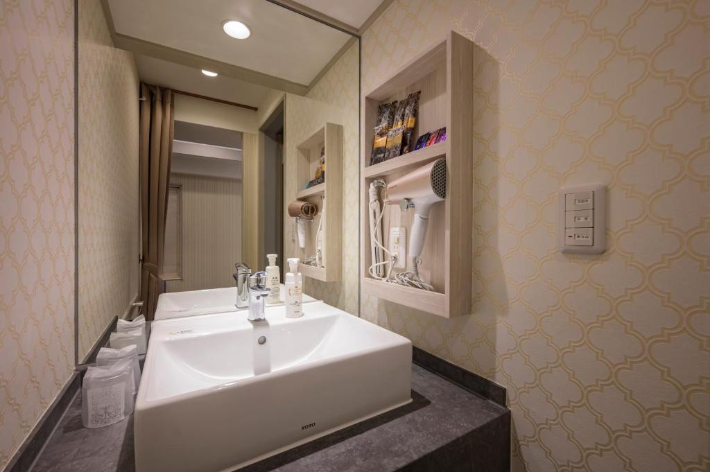 une salle de bain avec un lavabo blanc et un miroir dans l'établissement Hotel Plantan - Adult Only, à Tokyo 20 autres photos