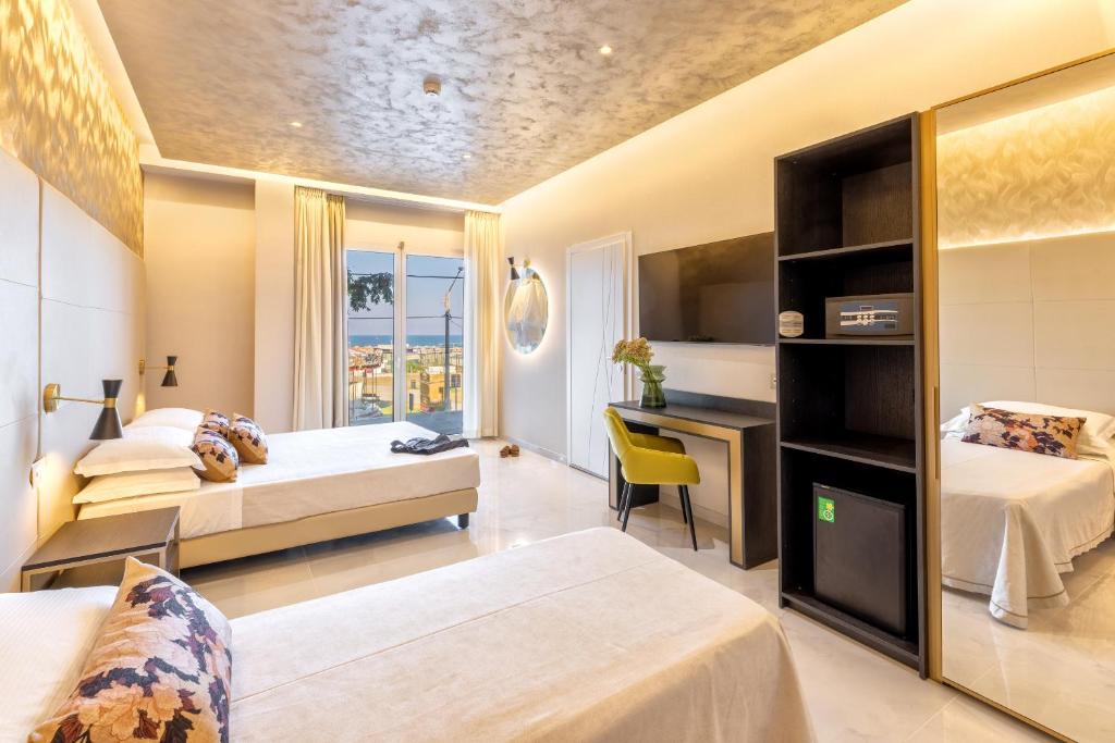 une chambre d'hôtel avec deux lits et un bureau dans l'établissement Hotel Mondial, à Rimini