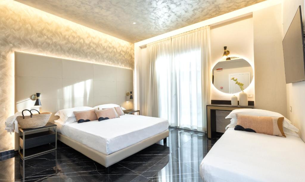 deux lits dans une chambre avec un miroir dans l'établissement Hotel Mondial, à Rimini