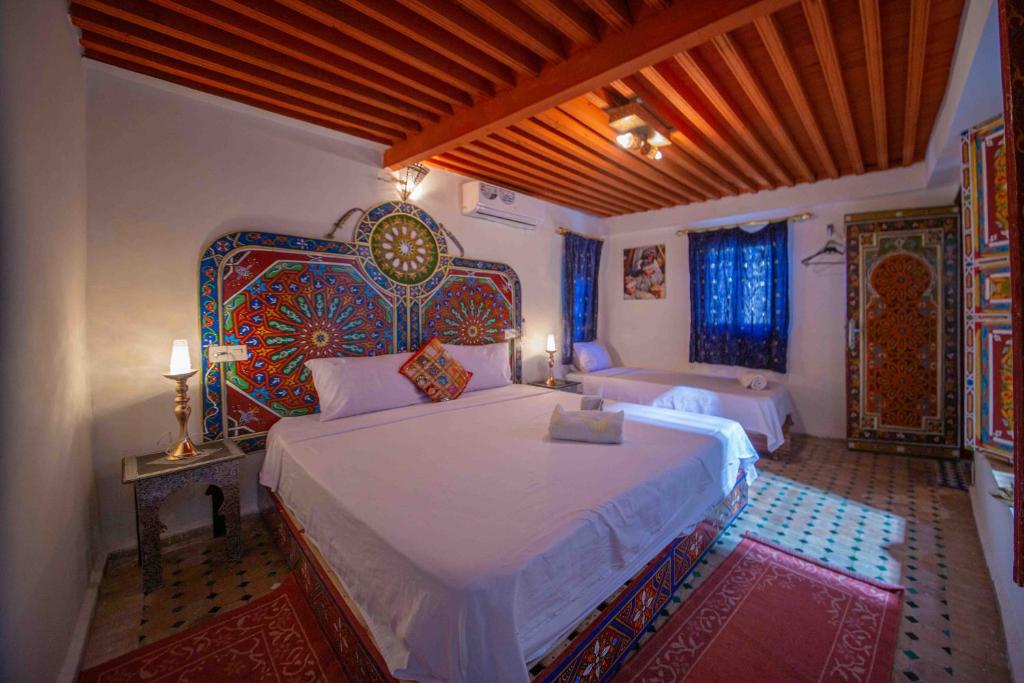 une chambre avec un grand lit avec une tête de lit dans l'établissement Riad Fes Hayat - Confort Stay, à Fès