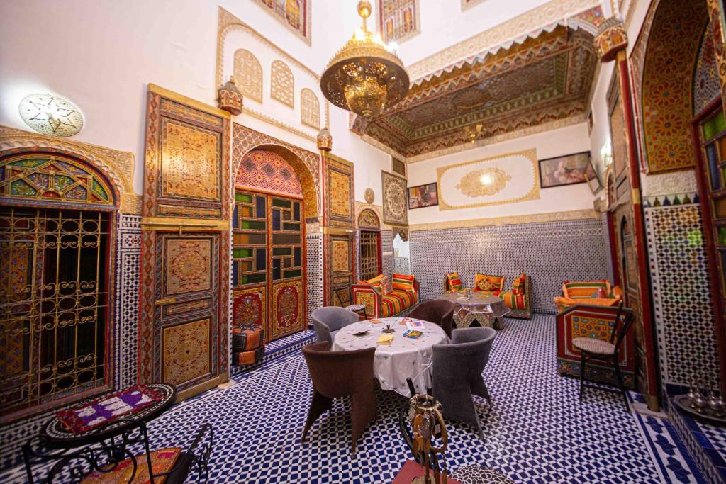 une pièce avec une table et des chaises dans un bâtiment dans l'établissement Riad Fes Hayat - Confort Stay, à Fès