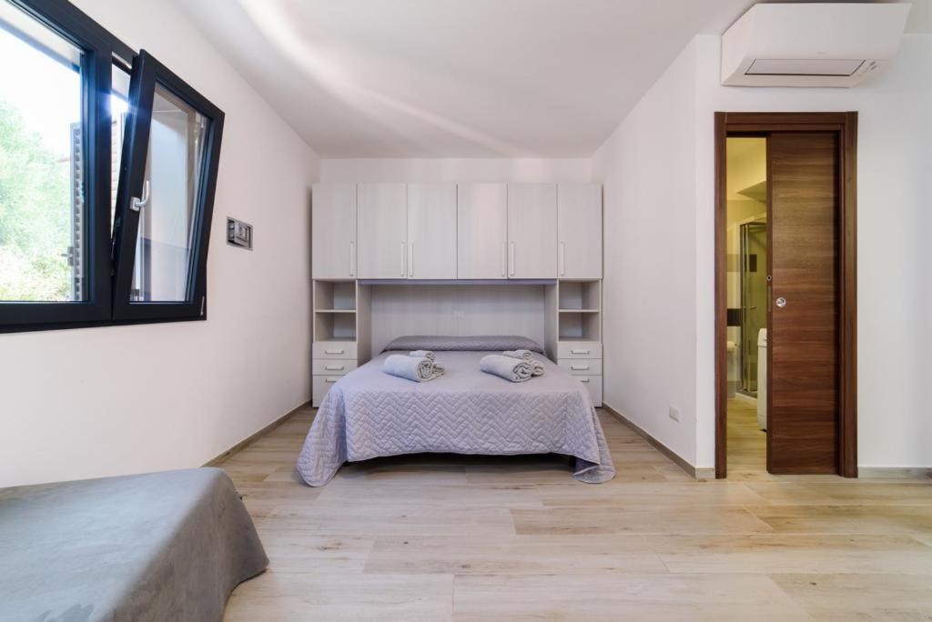 une chambre blanche avec un lit et une fenêtre dans l'établissement Casa Vacanze Maraldo, à Marina di Camerota