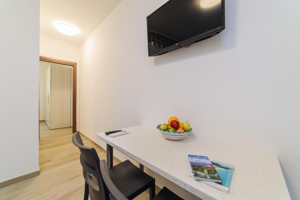 Cette chambre comprend une table avec des chaises et une corbeille de fruits. dans l'établissement Casa Vacanze Maraldo, à Marina di Camerota