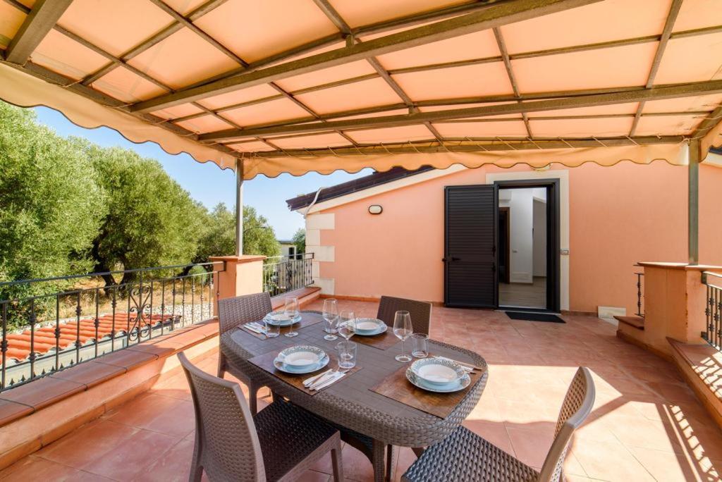 un patio avec une table et des chaises sur une terrasse dans l'établissement Casa Vacanze Maraldo, à Marina di Camerota