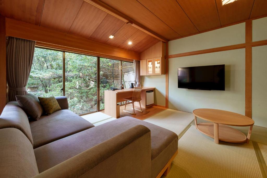 un salon avec un canapé, une télévision et une table dans l'établissement Matsudaya Hotel, à Yamaguchi 37 autres photos
