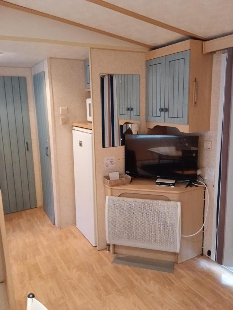 un salon avec une télévision et une table avec une chaise dans l'établissement Mobil home Gassin, à Gassin