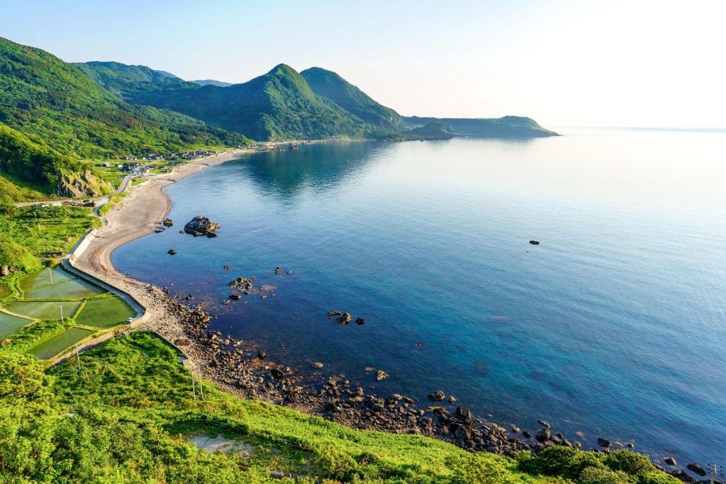 une vue aérienne d'une plage et de l'océan dans l'établissement Sado Ryosou Minato, à Sado