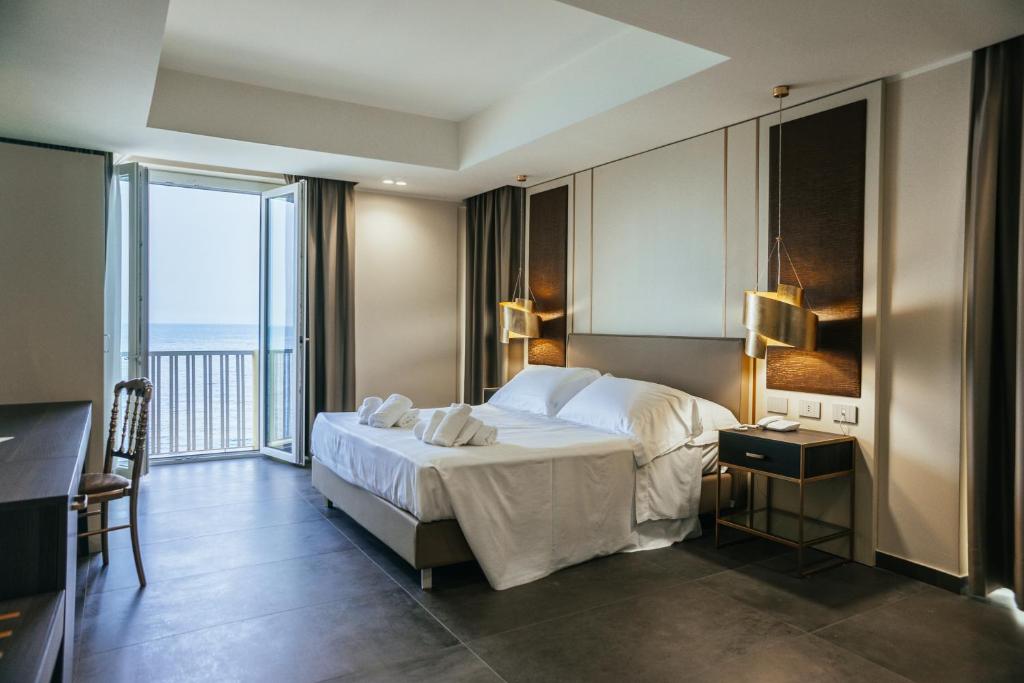 une chambre d'hôtel avec un lit et un balcon dans l'établissement Hotel Palace, à Catanzaro Lido 77 autres photos