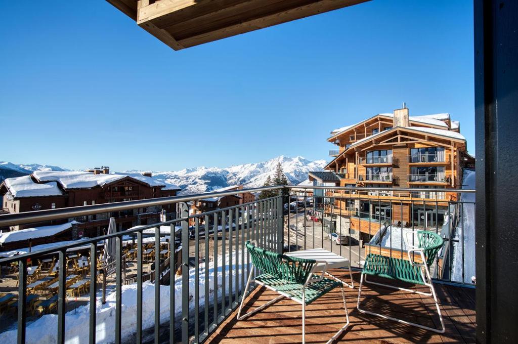 - un balcon avec deux chaises et une table dans l'établissement Lodge des Glaciers - La Rosière, à Montvalezan