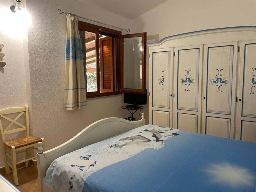 une chambre avec un grand lit avec une couverture bleue dans l'établissement villa elena piscina privata, à Tanaunella 69 autres photos