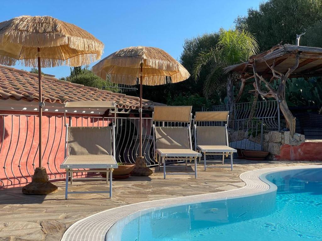 un groupe de chaises et de parasols à côté d'une piscine dans l'établissement villa elena piscina privata, à Tanaunella