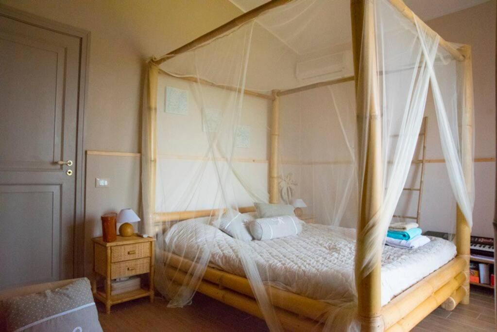 - une chambre avec un lit à baldaquin et des oreillers blancs dans l'établissement SERENDIPITY VILLA sea view, sun and Etna, à Agnone Bagni 34 autres photos