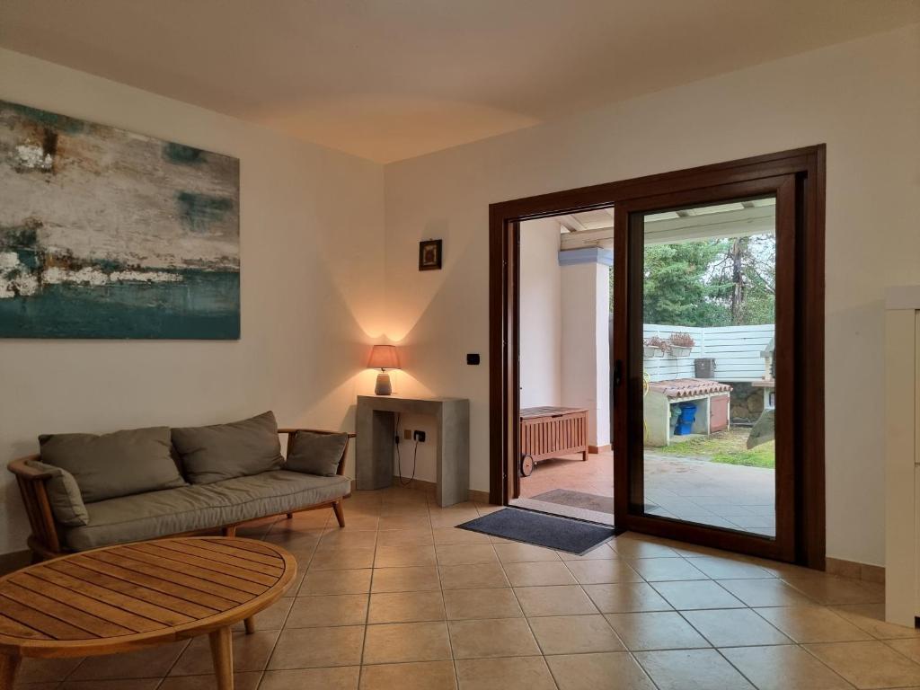 un salon avec un canapé et une table dans l'établissement Res S'Abbaida C1 con Piscina Privata, à Tanaunella