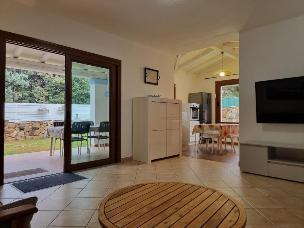 un salon avec une cuisine et une salle à manger dans l'établissement Res S'Abbaida C1 con Piscina Privata, à Tanaunella