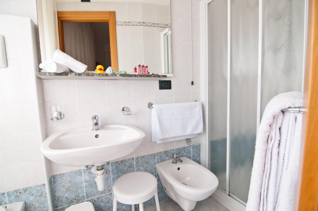 une salle de bain avec un lavabo et des toilettes dans l'établissement Hotel Milan, à Rosolina Mare