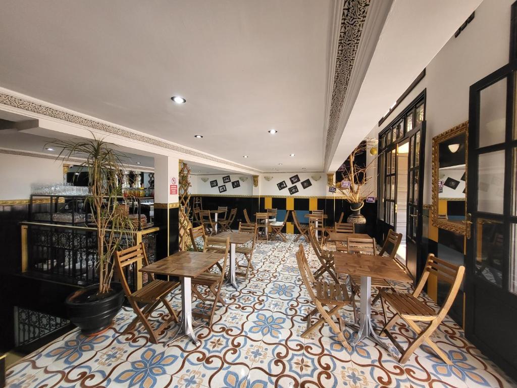 - un restaurant avec des tables et des chaises en bois dans une chambre dans l'établissement Riad Soir De Marrakech, à Marrakech