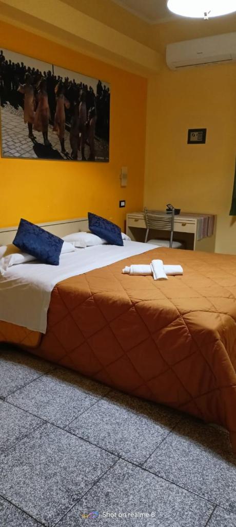une chambre avec un grand lit avec des oreillers bleus dans l'établissement Hotel Mariagrazia, à Calopezzati
