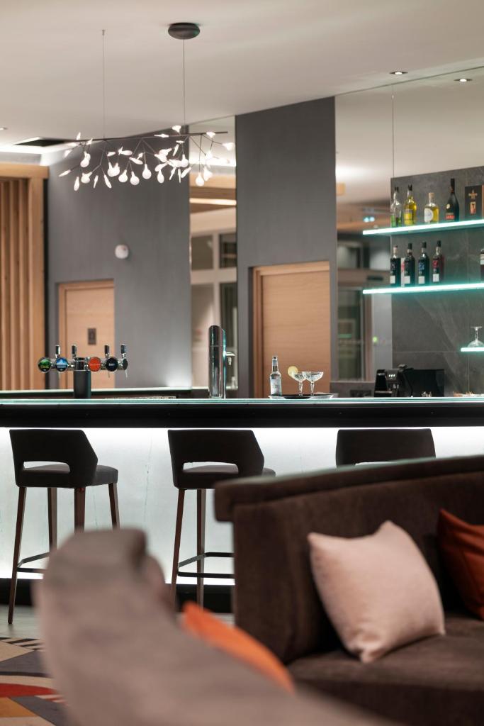 - un bar avec un canapé et des chaises dans la chambre dans l'établissement MGM Hôtels & Résidences - Résidence Alhéna, à Flaine