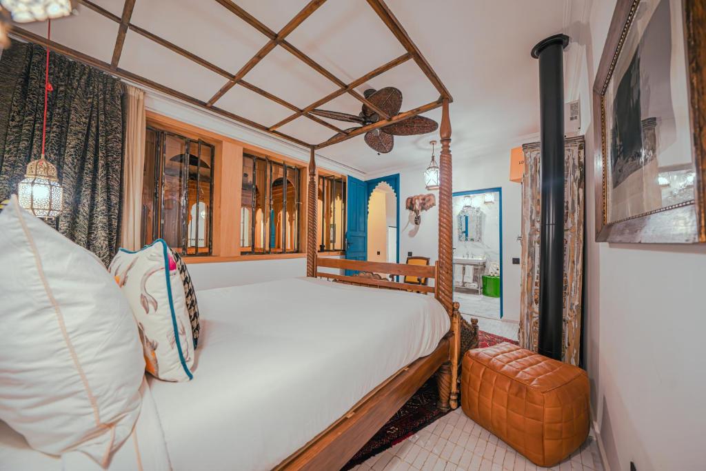 - une chambre avec un lit à baldaquin et un ventilateur dans l'établissement Riad Tibibt, à Marrakech