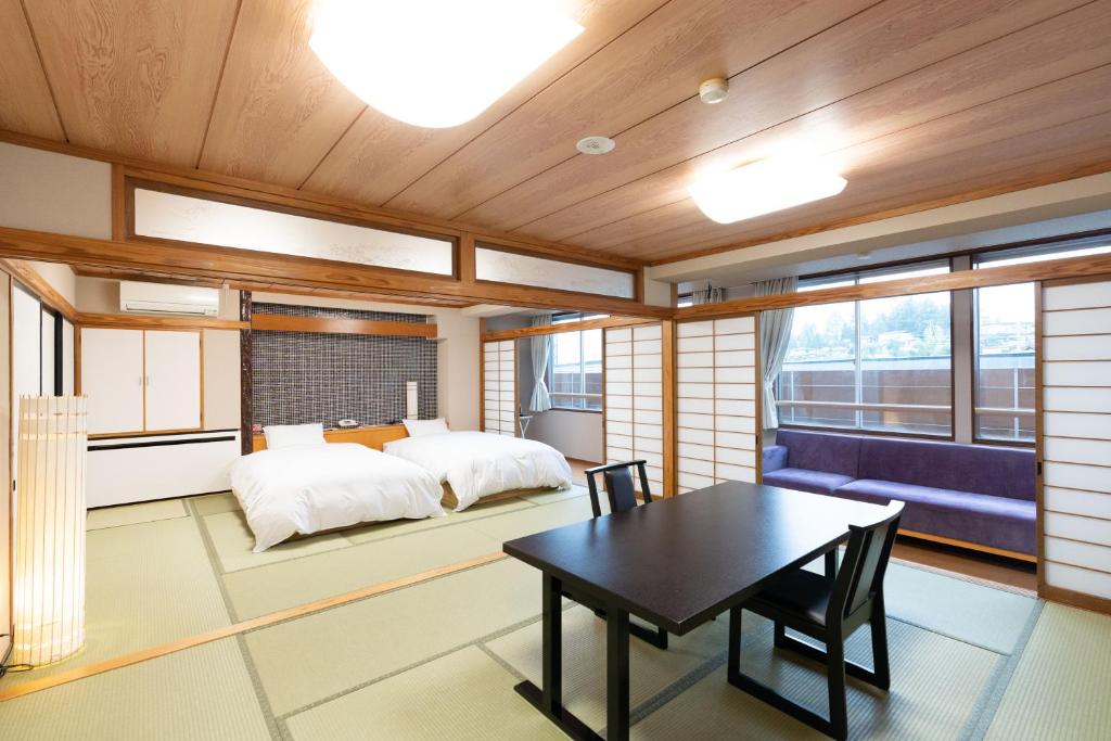 une chambre avec un lit, une table et des chaises dans l'établissement Arimakan, à Kaminoyama
