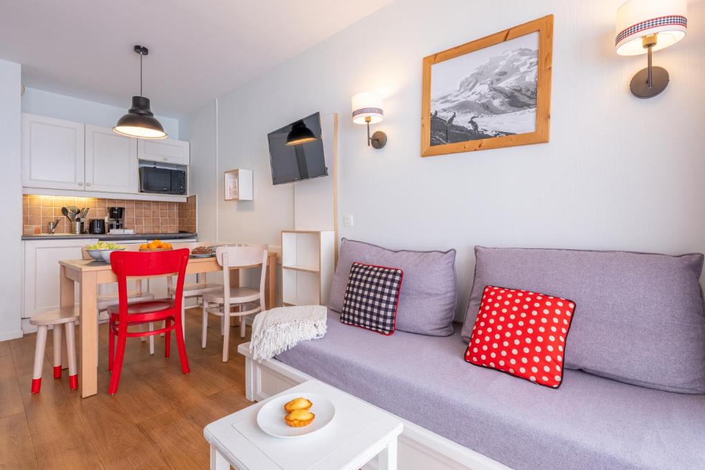 un salon avec un canapé et une table et une cuisine dans l'établissement Résidence Pierre & Vacances Le Thabor, à Valmeinier 32 autres photos