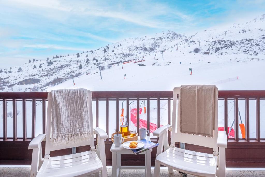 2 chaises et une table sur un balcon avec une piste de ski dans l'établissement Résidence Pierre & Vacances Le Thabor, à Valmeinier 28 autres photos