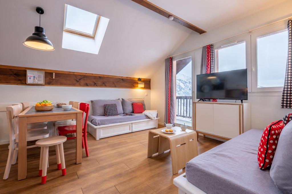 un salon avec un canapé et une table dans l'établissement Résidence Pierre & Vacances Le Thabor, à Valmeinier