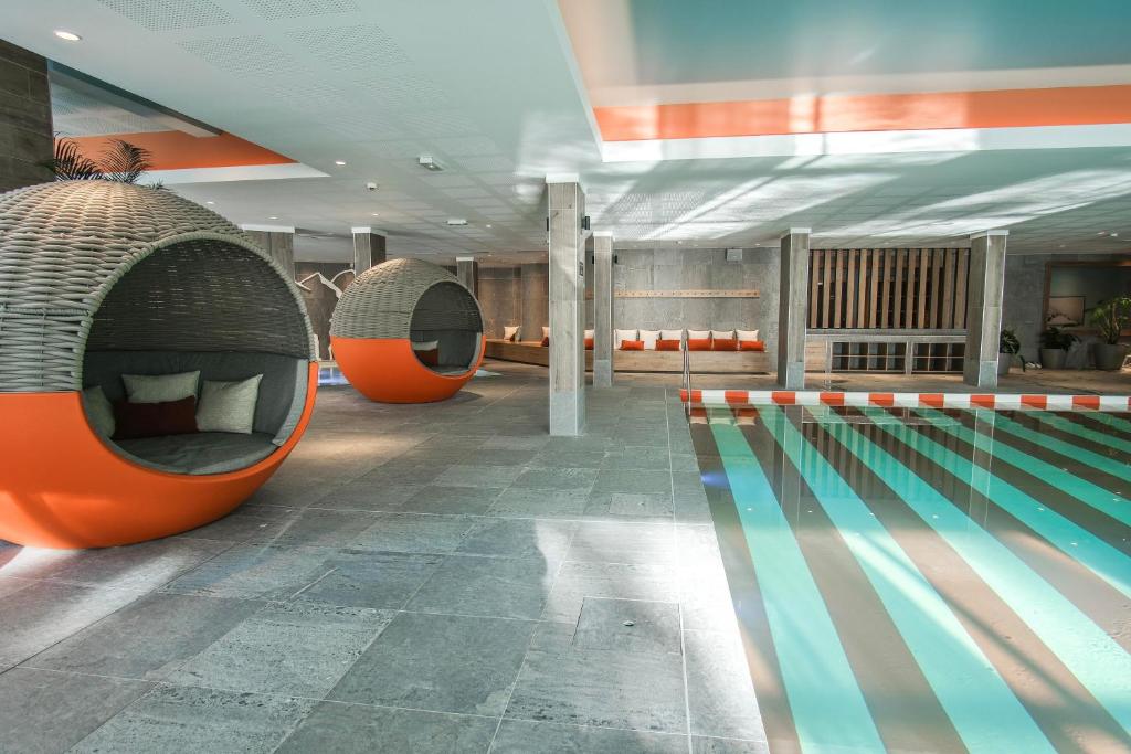- une piscine avec 2 chaises à côté dans l'établissement Belambra Clubs Flaine Panorama, à Flaine