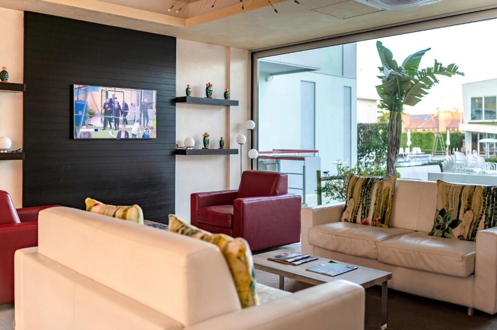 un salon avec deux canapés et une table dans l'établissement Domino Suite Hotel & Residence, à Lido di Jesolo 78 autres photos