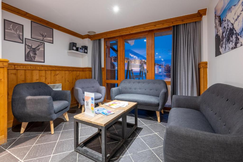 - une salle d'attente avec trois chaises et une table dans l'établissement Résidence Pierre & Vacances Le Mont Soleil, à La Plagne